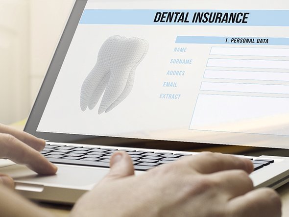 Person filling out dental insurance form on laptop