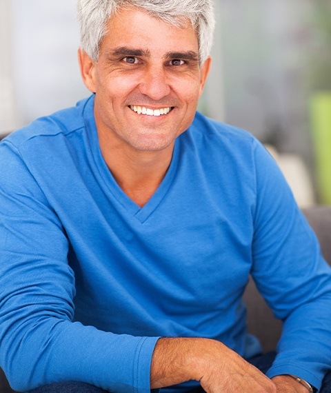 Man in blue shirt smiling with All on 4 dental implants in Dallas