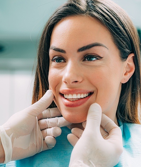 Oral surgeon examining patients smile after bone grafting in Dallas