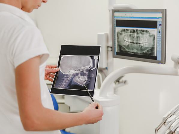Oral surgeon examining x rays of jaw and skull bones