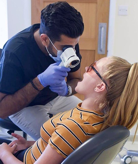 Dentist examining patient for oral pathology in Dallas
