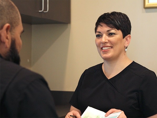Oral surgery team member and patient reviewing dental implant costs