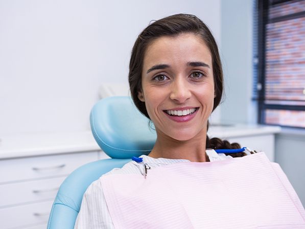 Woman smiling after discussing bone grafting costs