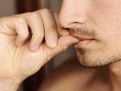 Man chewing on fingernails, a bad habit for dental implants