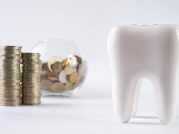 Tooth next to a bowl full of coins