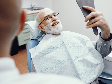 After New Teeth Are Attached: Man smiling in the dental chair
