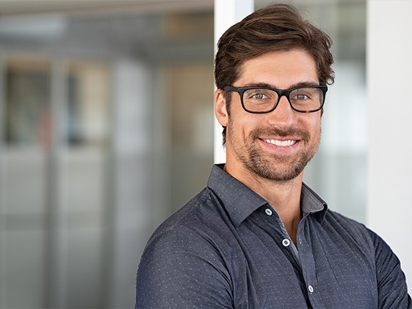 Smiling man in glasses and gray collared shirt